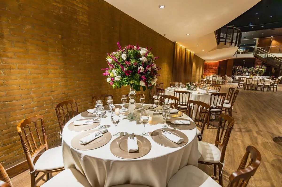 Interior de restaurante de lujo con configuración de mesa elegante y centro de mesa floral. Ambiente perfecto para recepciones y eventos (imagen de referencia)