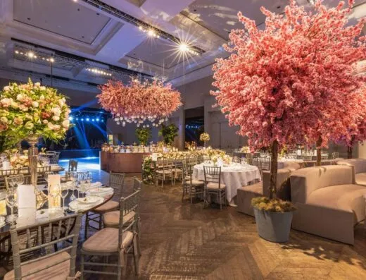 Recepción de boda elegante con flores de cerezo y decoraciones lujosas en un entorno exclusivo.