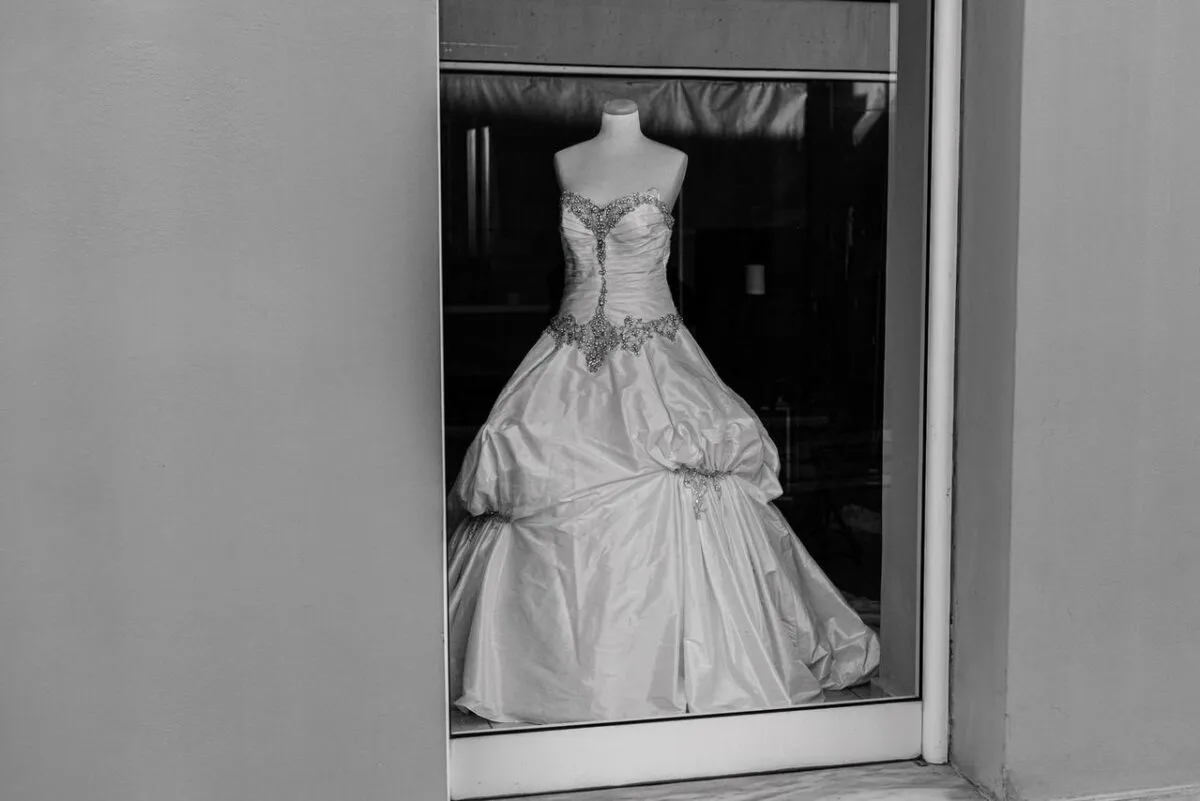 Una elegante toma en monocromo de un vestido de novia en un mannequin en la ventana de una boutique (imagen de referencia)