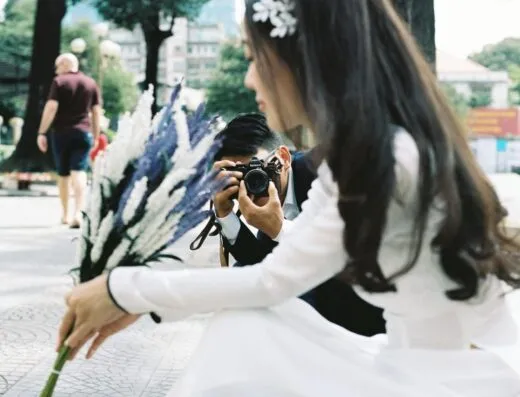 Momento espontáneo de una novia siendo fotografiada al aire libre en Ciudad Ho Chi Minh.