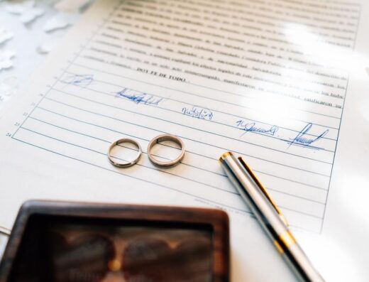 Elegantes anillos de boda colocados sobre un certificado de matrimonio firmado, simbolizando el compromiso.