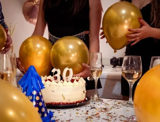 Fiesta alegre del 30 cumpleaños con globos dorados, pastel y bebidas festivas.