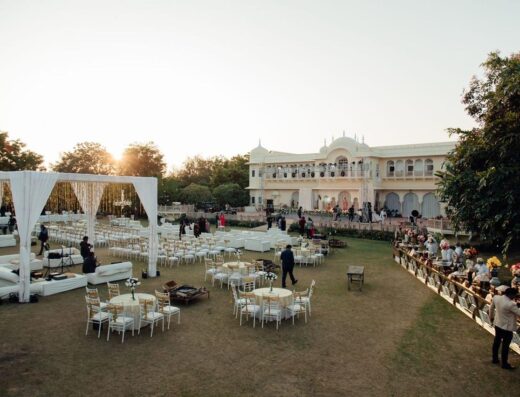 Una lujosa boda al aire libre en una gran villa durante el atardecer, que muestra elegancia y opulencia.