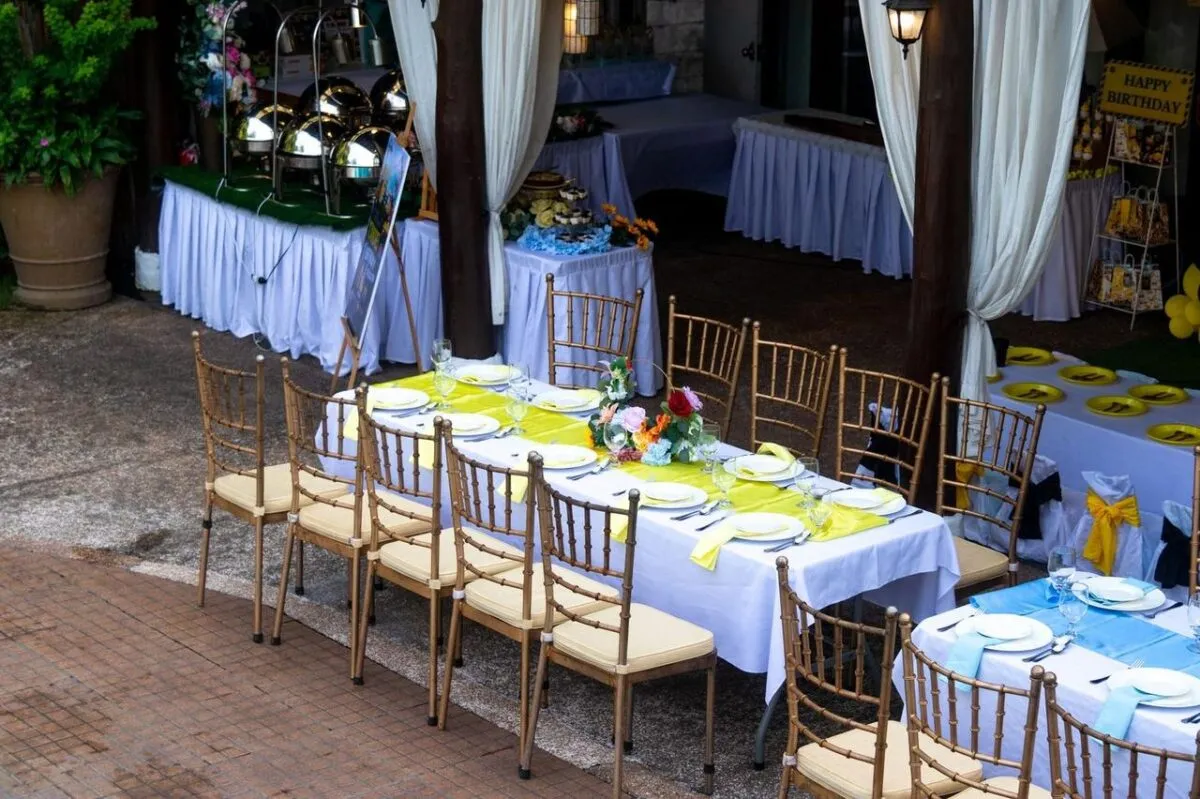 Una hermosa disposición de comedor al aire libre para una fiesta de cumpleaños con decoraciones vibrantes y arreglos de mesa (imagen de referencia)