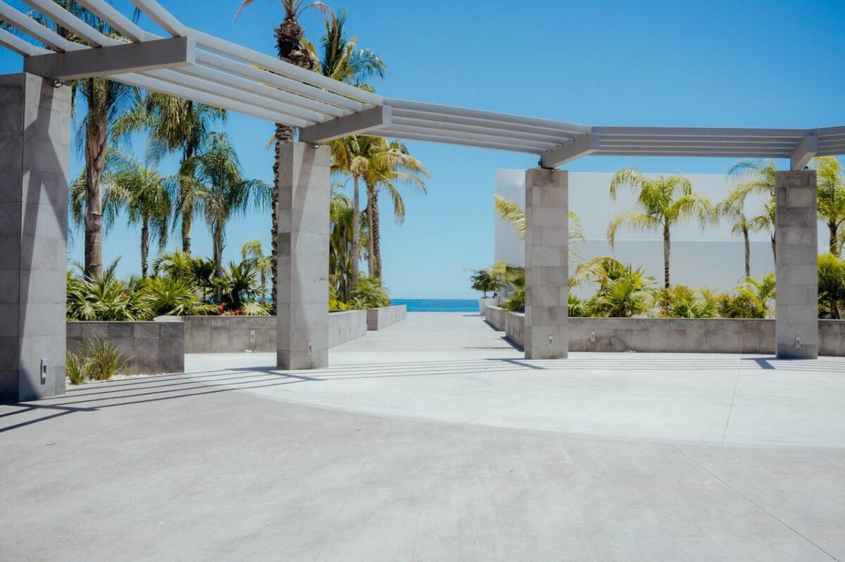 Un pabellón exterior contemporáneo con palmeras y vistas al mar, ideal para eventos (imagen de referencia)