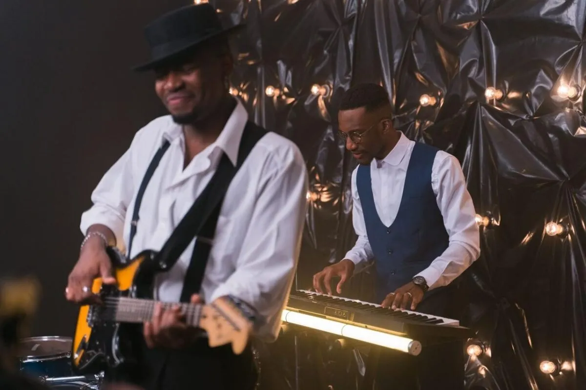 Actuación de música en vivo dinámica con un guitarrista y un tecladista en un entorno interior elegante (imagen de referencia)