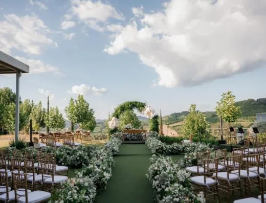 Hermoso lugar para bodas al aire libre con decoración floral y un paisaje pintoresco.