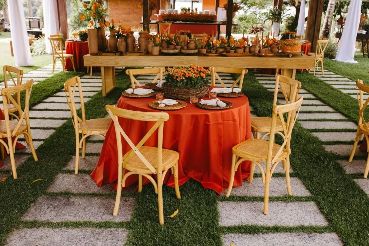 Encantador escenario para bodas al aire libre con decoración de terracota y sillas rústicas de madera, perfecto para una celebración festiva (imagen de referencia)