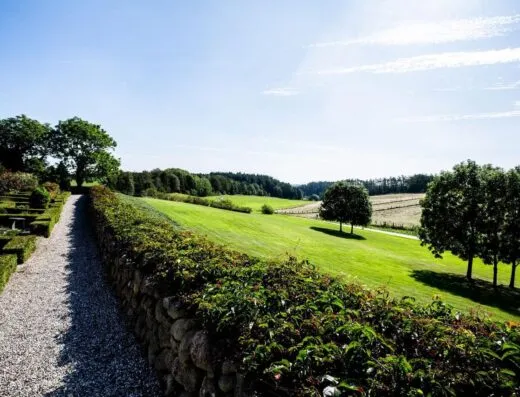 Hermoso jardín con un camino de piedra y vegetación exuberante bajo un cielo soleado.