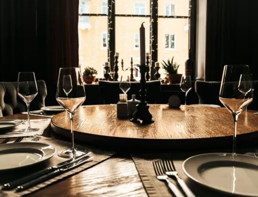 Una mesa de comedor bellamente puesta con una atmósfera iluminada por velas, perfecta para reuniones elegantes.