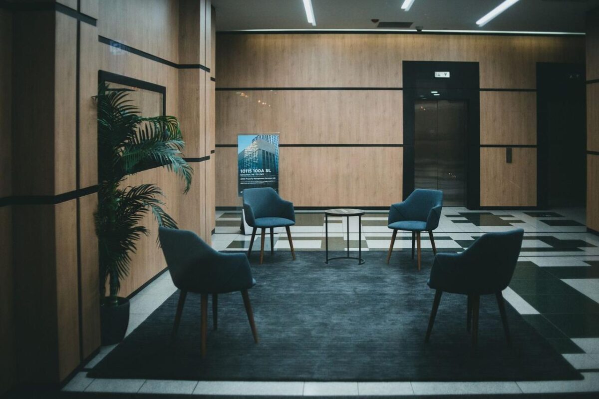 Un vestíbulo de oficina elegante con sillas modernas y un diseño minimalista en un tono neutro (imagen de referencia)