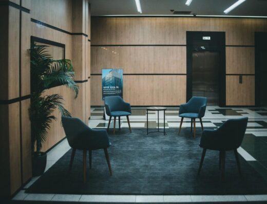 Un vestíbulo de oficina elegante con sillas modernas y un diseño minimalista en un tono neutro.