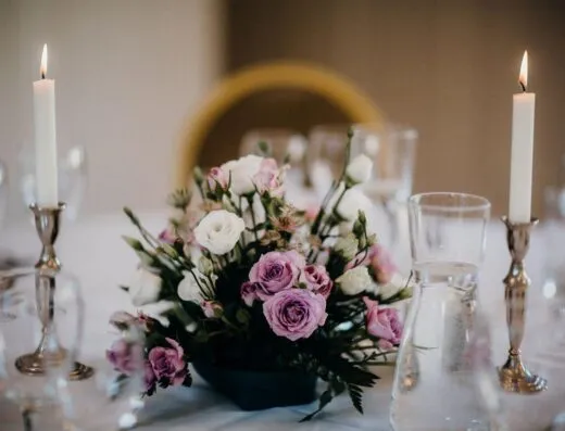 Hermoso centro de mesa floral con velas en una mesa de boda.
