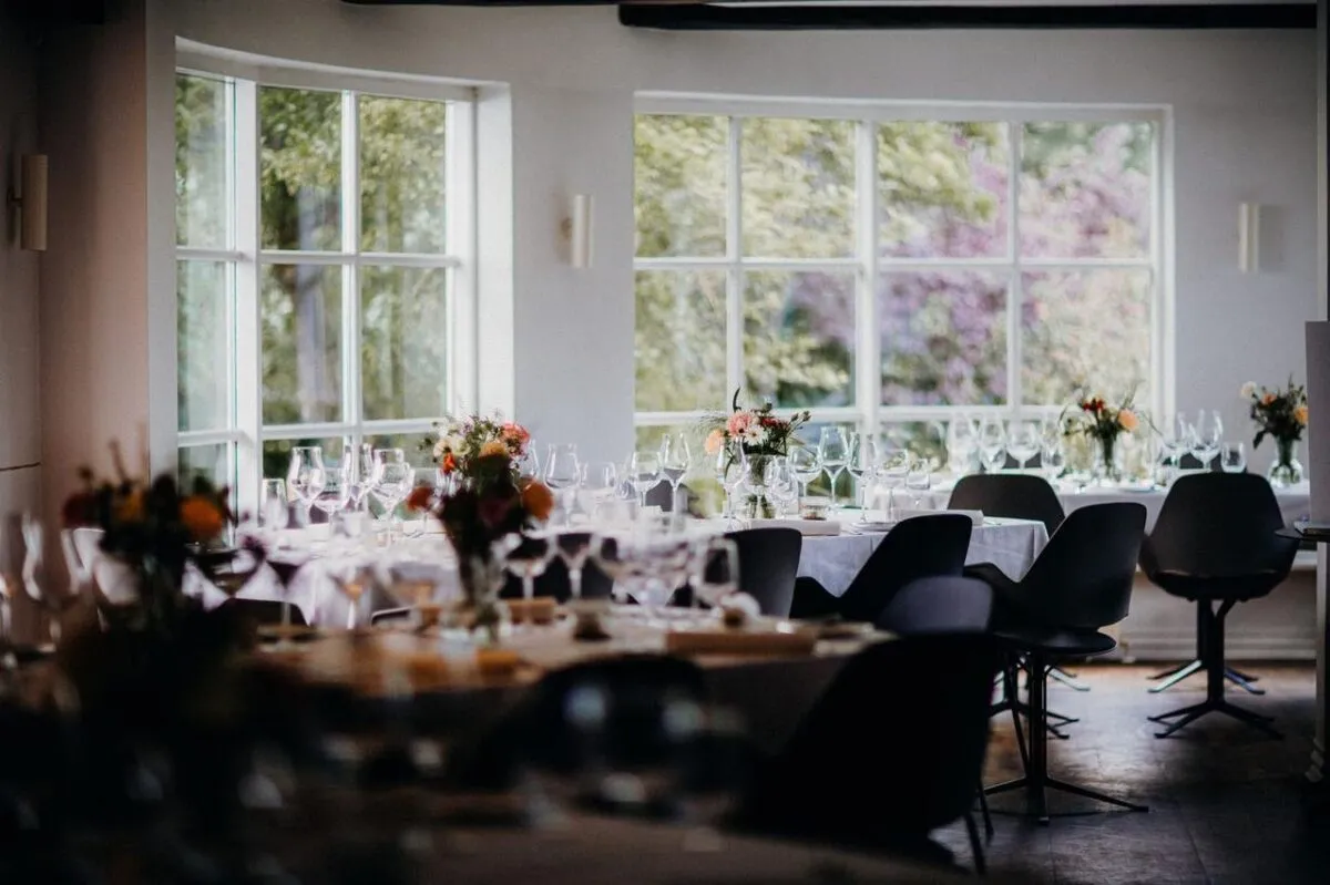 Comedor de restaurante sofisticado con una elegante decoración de mesa para un evento formal o recepción (imagen de referencia)