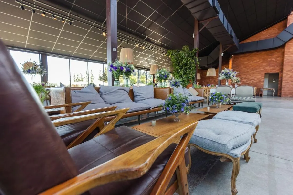 Amplio salón de banquetes con muebles modernos y exuberante decoración floral (imagen de referencia)