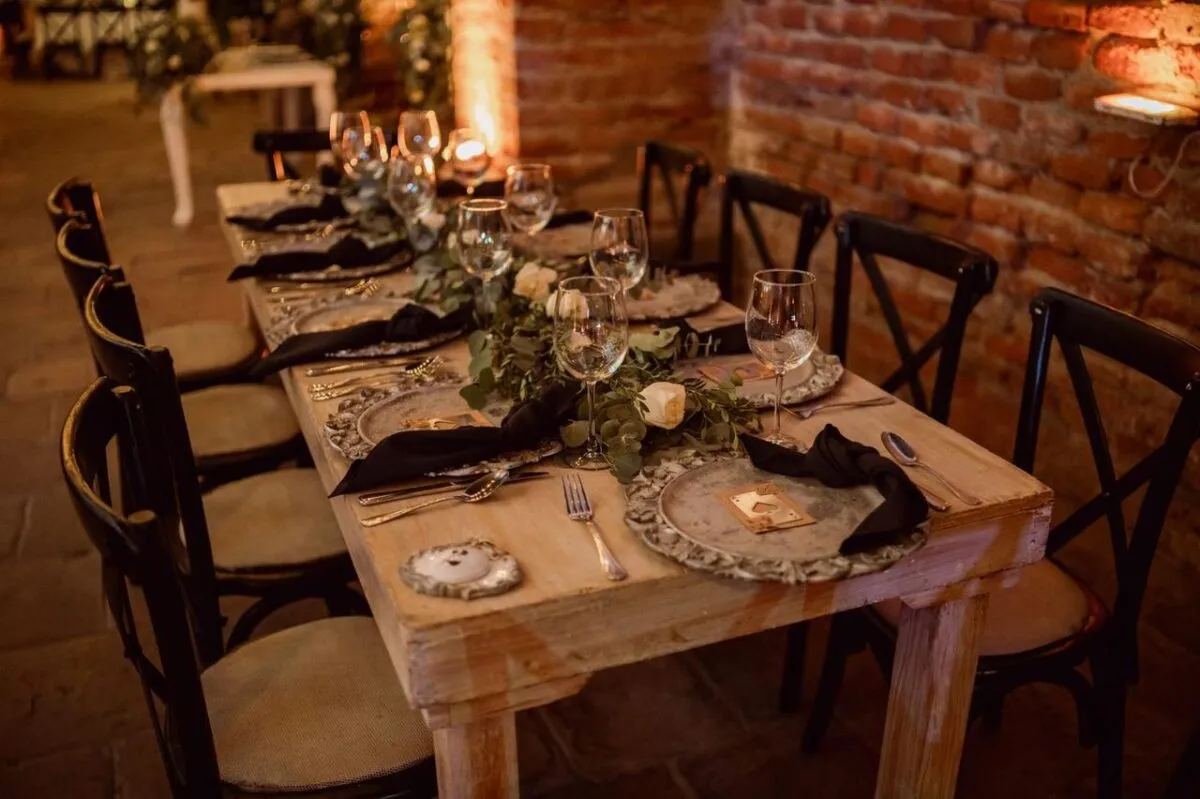 Una mesa de boda rústica bellamente decorada con vajilla elegante y decoración floral (imagen de referencia)