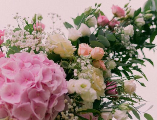 Hermoso ramo floral con hortensias, rosas y vegetación en suaves tonos pastel.