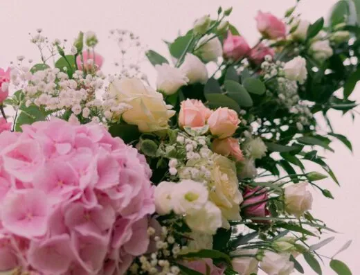 Hermoso ramo floral con hortensias, rosas y vegetación en suaves tonos pastel.