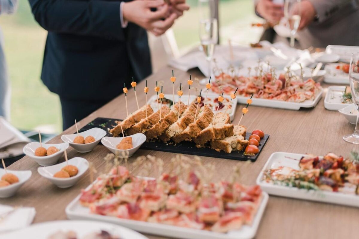 Una variedad de aperitivos exhibidos elegantemente en una mesa de buffet en un evento social (imagen de referencia)