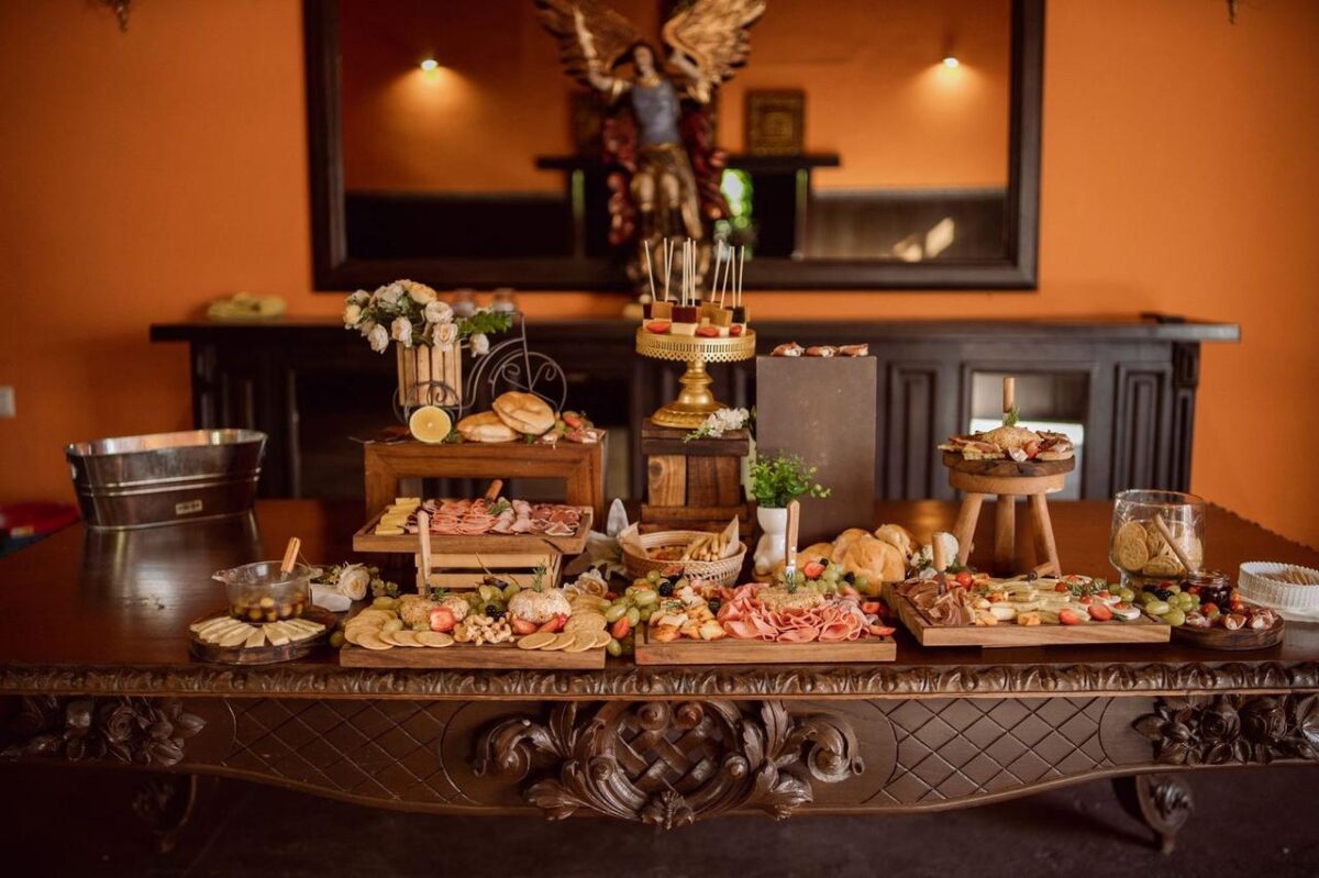 Una mesa de buffet bellamente dispuesta con una variedad de quesos, embutidos y una decoración elegante (imagen de referencia)