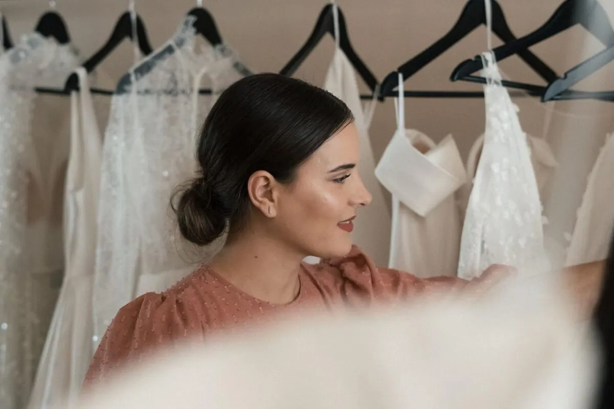 Novia en proceso de seleccionar un vestido de boda en una boutique elegante (imagen de referencia)