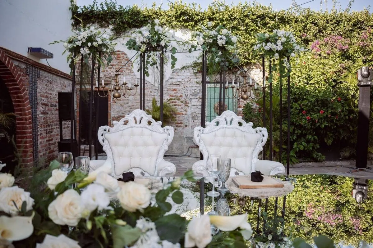 Configuración de boda al aire libre con sillas elegantes, decoración floral y acentos rústicos, perfecta para eventos románticos (imagen de referencia)