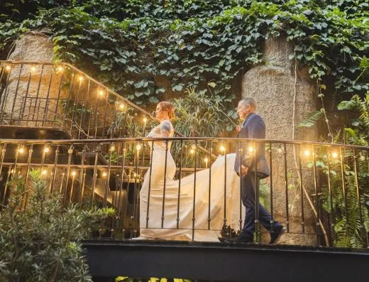 Escalera iluminada del patio de Kampanas, con una pareja de novios