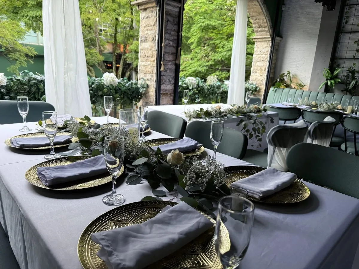 Mesa montada para una boda en Kampanas, con platos dorados y flores