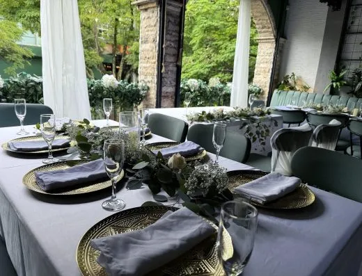 Mesa montada para una boda en Kampanas, con platos dorados y flores