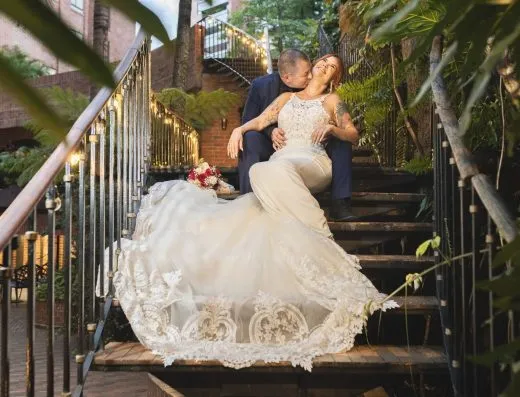 Pareja de novios sentada en la escalera del patio de Kampanas